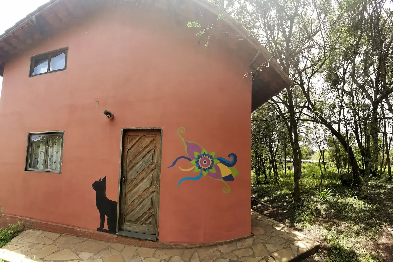 Fachada da casa de Elisete antes do incêndio, cercada pela natureza